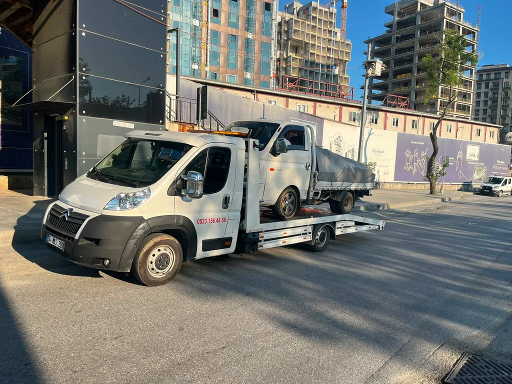 Akbulut Yol Yardım çekicisi gündüz İstanbul'da bir kamyoneti platformda taşırken