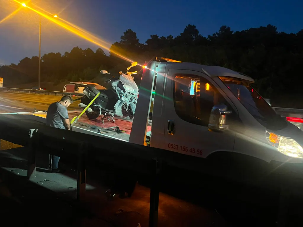 Akbulut Yol Yardım çekicisi gece otoyol kenarında bir motosikleti platforma bağlarken