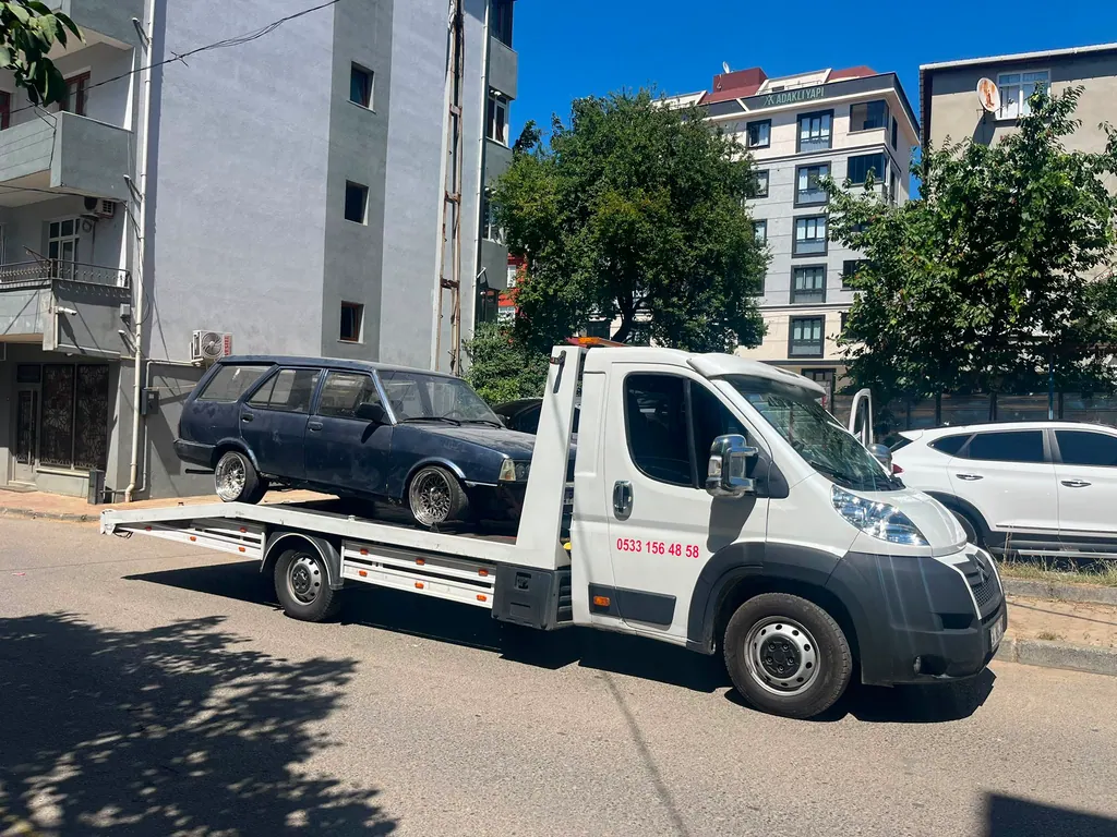 Akbulut Yol Yardım çekicisi bir mahalle sokağında klasik bir station aracı taşırken
